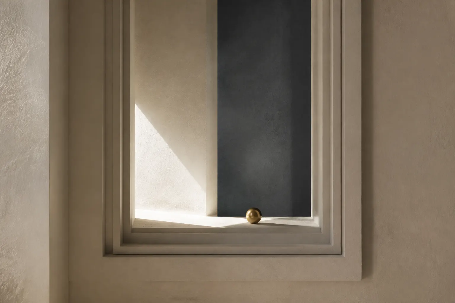 A gold sphere resting on the ledge of a stepped rectangular recess in a plaster wall.