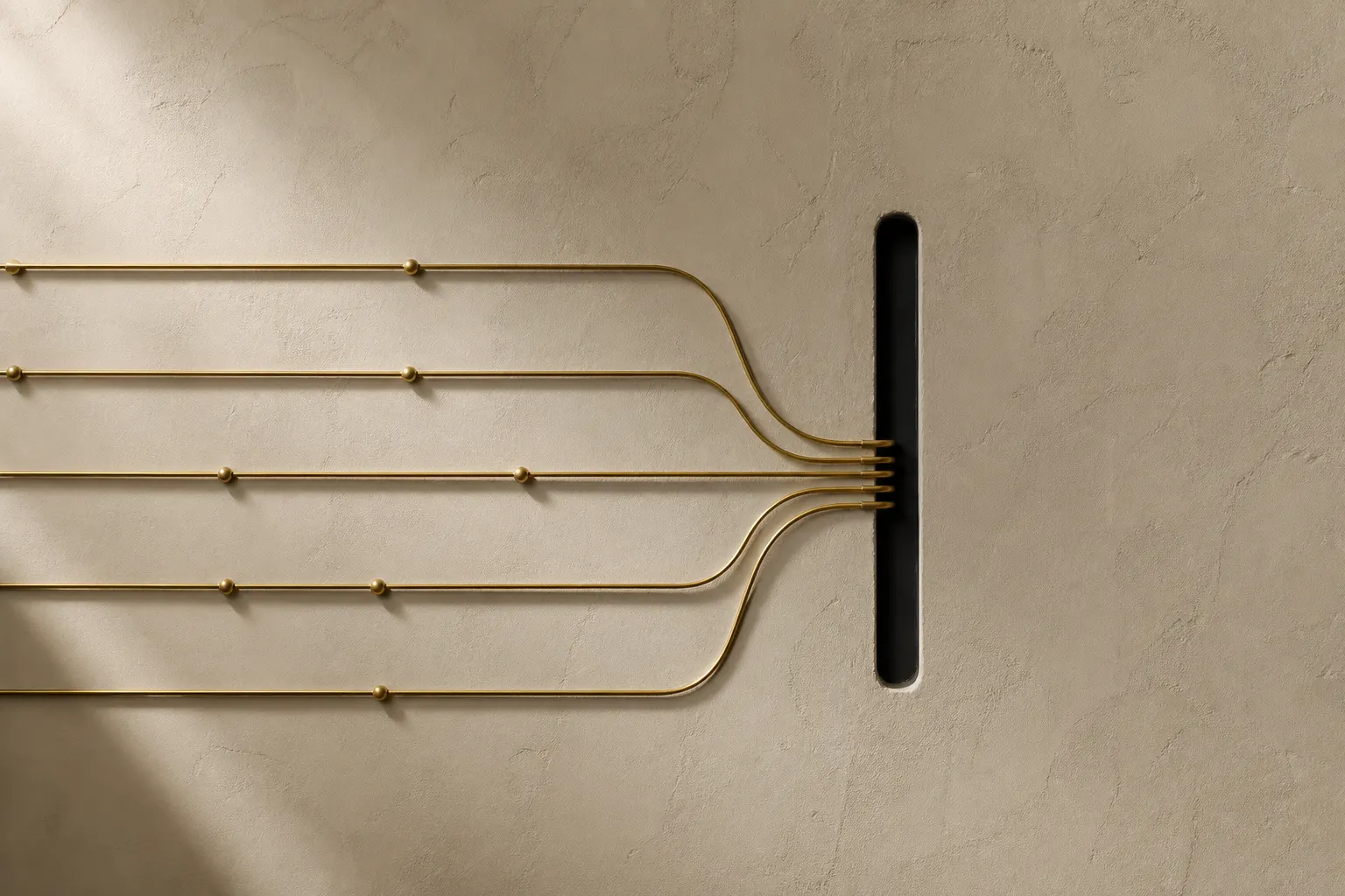 Five brass rods with spherical nodes converging into a vertical slot on a plaster wall.