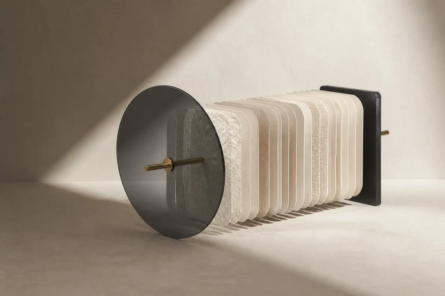 Textured plates and a smoked-glass disc threaded on a brass rod that ends in a black block.